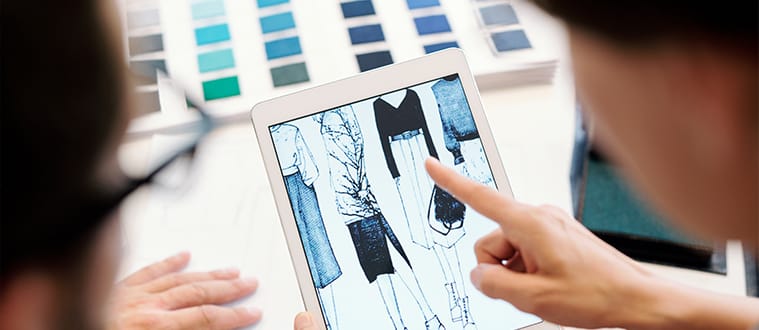Deux personnes qui regardent des designs de vêtements sur une tablette