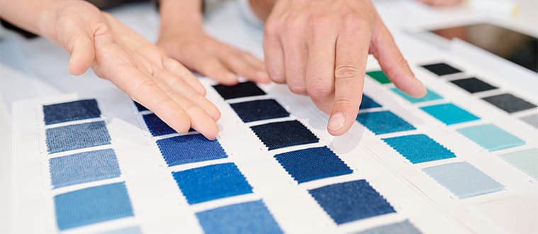 Deux personnes décidant de la couleur du tissu qu'elle vont choisir pour fabriquer leurs vêtements